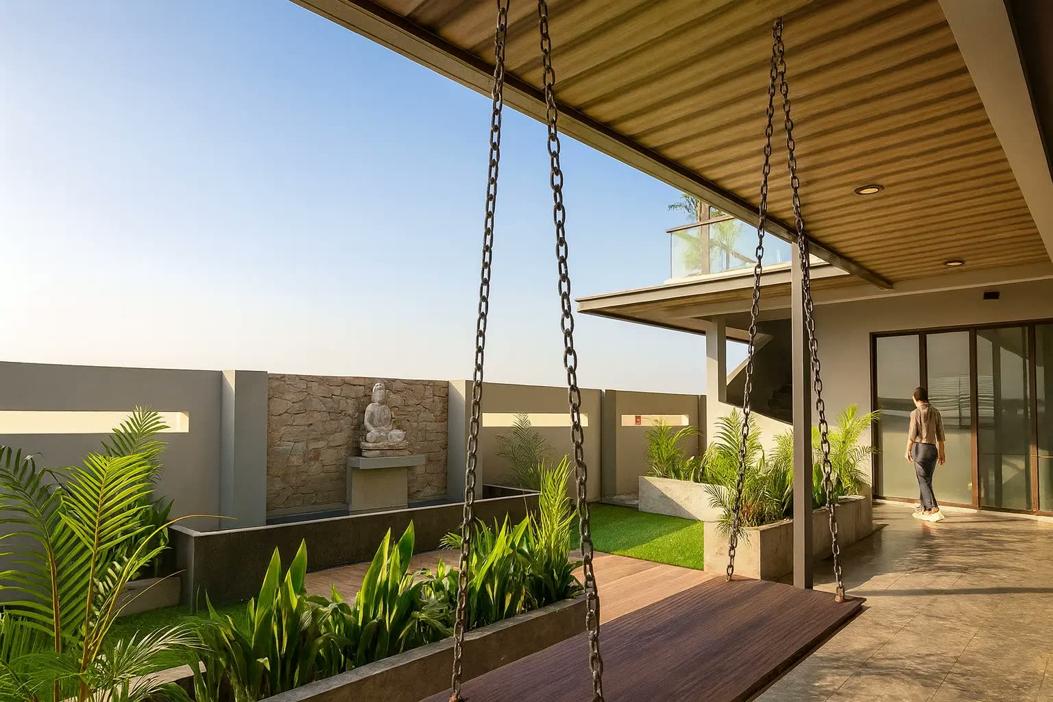 Outdoor courtyard with timber-lined ceiling, hanging timber swing, stone Buddha feature wall and tropical planter garden — home renovation by Winss Enterprise, Pusing Perak